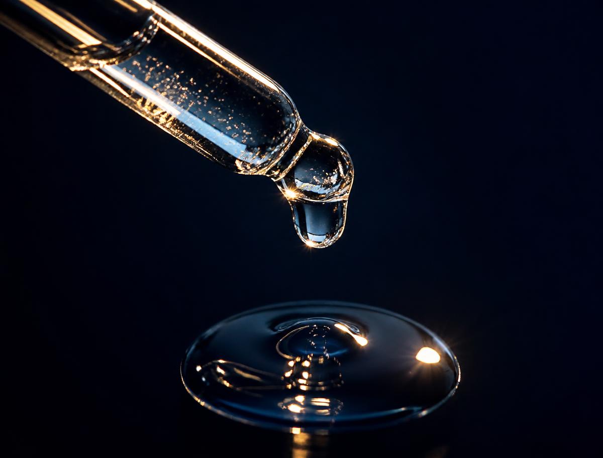Goutte de sérum de peeling professionnel sur fond bleu nuit